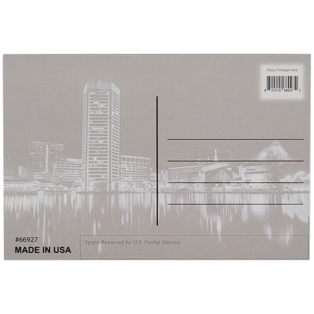 The back of a postcard featuring a gray version of the front of the postcard featuring the  Baltimore, Maryland harbor skyline at night. Place for a stamp and address lines are indicated.