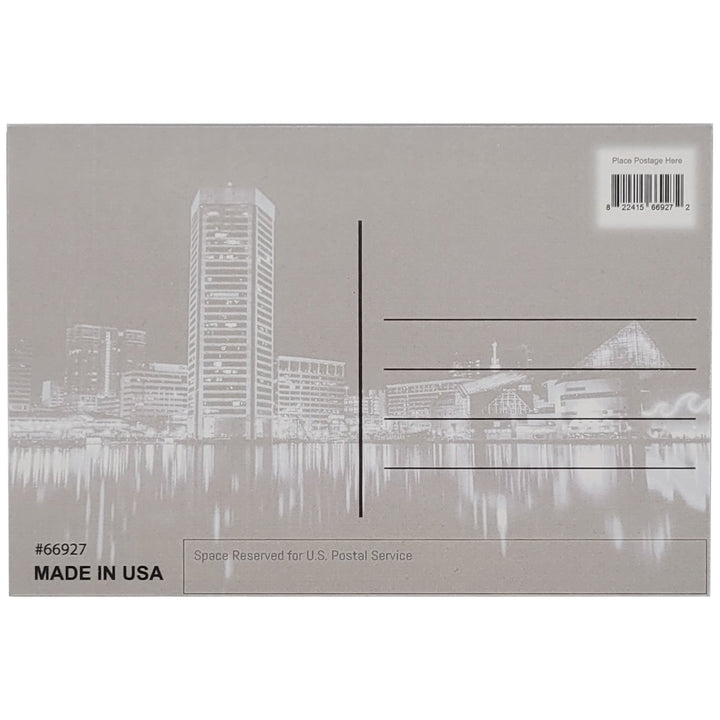 The back of a postcard featuring a gray version of the front of the postcard featuring the  Baltimore, Maryland harbor skyline at night. Place for a stamp and address lines are indicated.