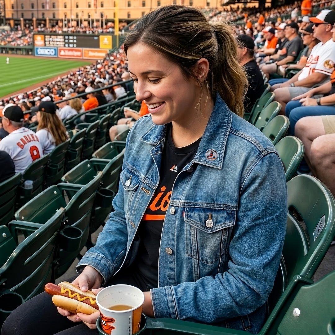 Woman at a baseball game wearing a denim jacket with her Baltimore Oriole and Crab Let&