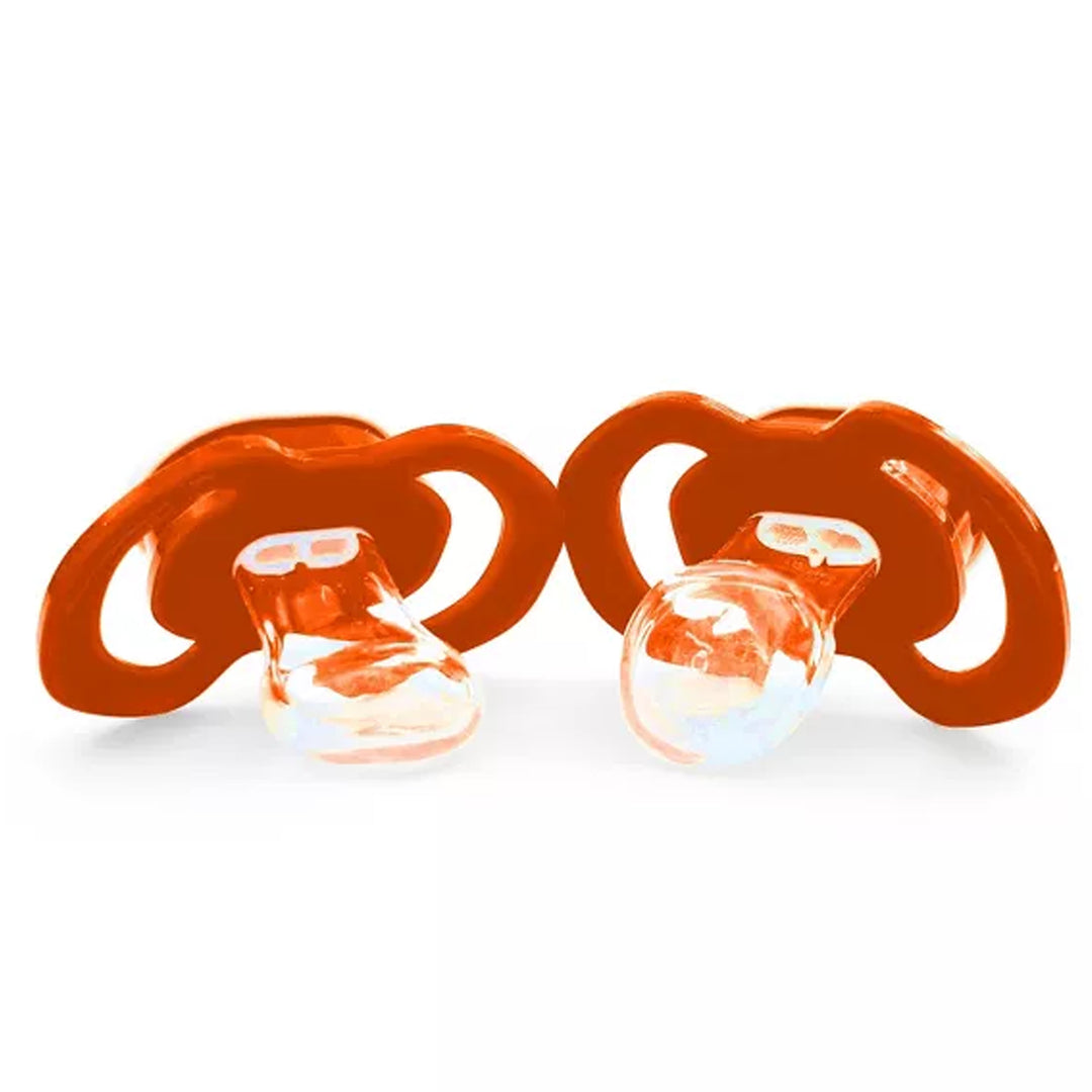 Two orange baby pacifiers on a white background