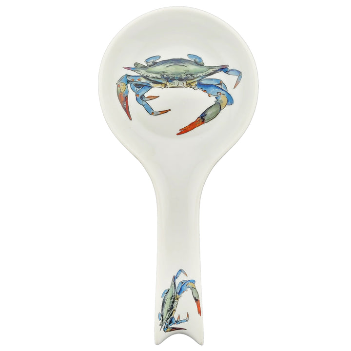 A white ceramic spoon rest with a blue crab illustration on the bowl and handle.