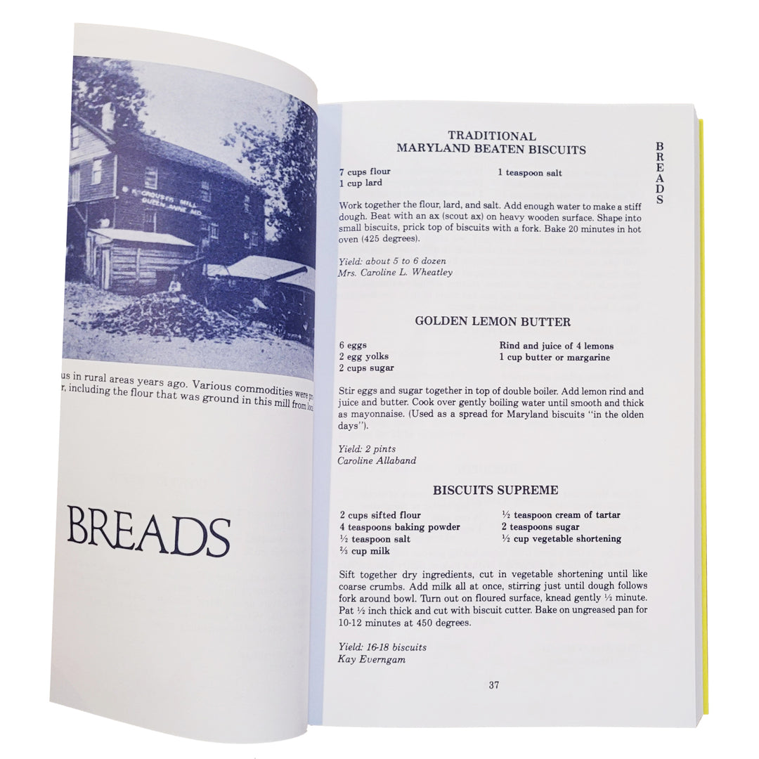 The Chesapeake Collection cookbook showing a printed recipe page with headings such as Traditional Maryland Beaten Biscuits, Golden Lemon Butter, and Biscuits Supreme, alongside a blue-and-white house photograph and the large word BREADS.