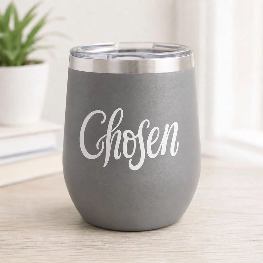 A gray insulated stemless wine tumbler with a clear lid and a vinyl sticker of the word &