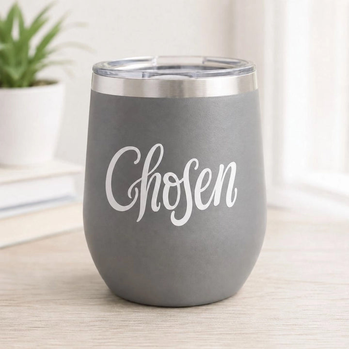 A gray insulated stemless wine tumbler with a clear lid and a vinyl sticker of the word &