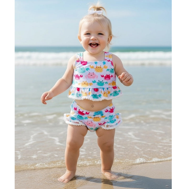 Child in a colorful crab swimsuit on a beach