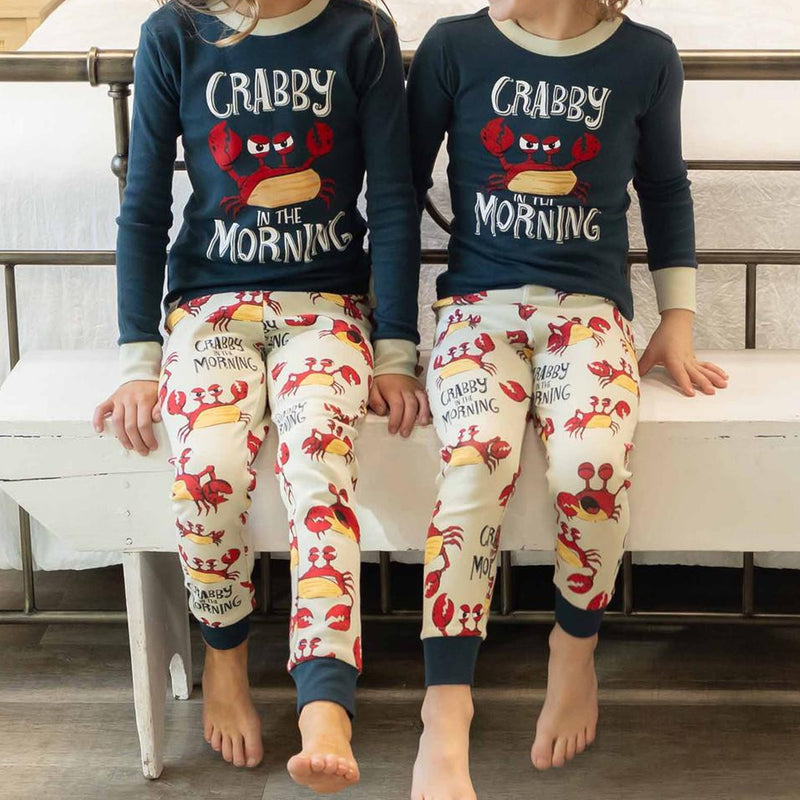 Two children wearing matching pajamas with a crab design and &