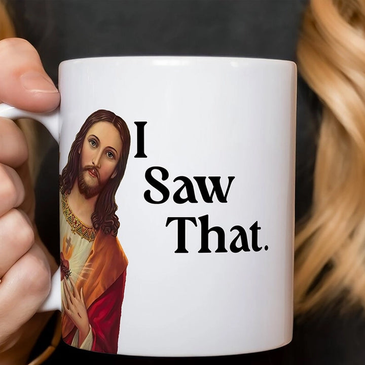 A hand holds a white ceramic mug featuring a printed image of Jesus on the left side and the bold black text &
