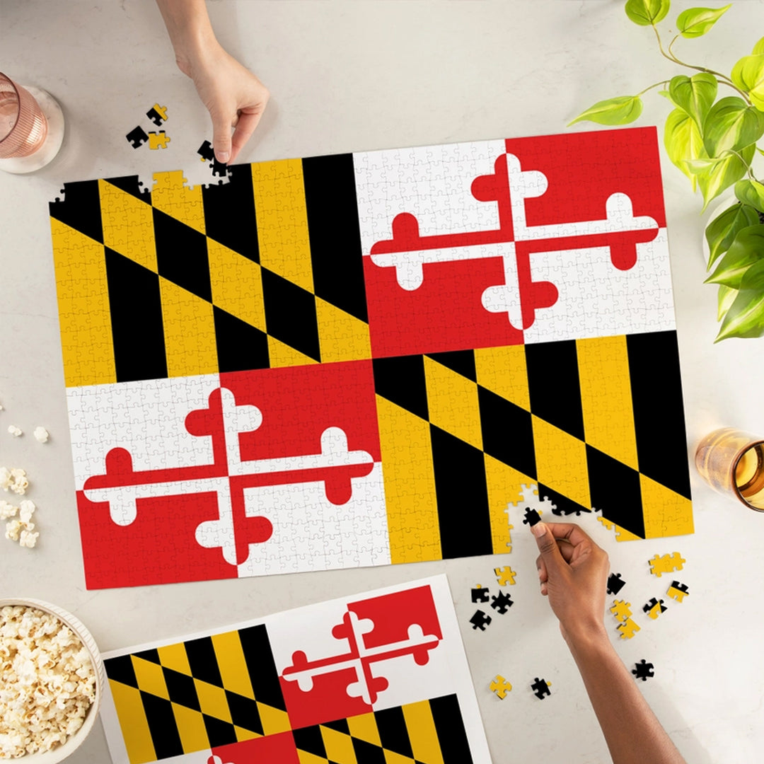 Puzzle with Maryland flag design on a table with hands assembling pieces.