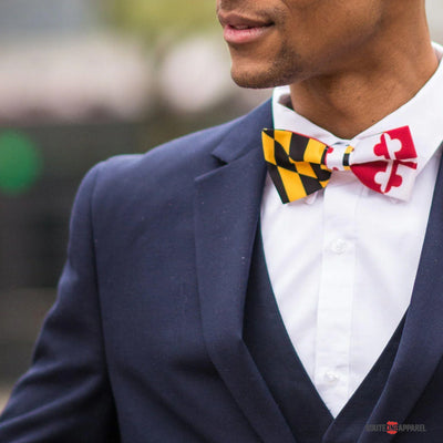 Man wearing a navy suit with a colorful bow tie outdoors
