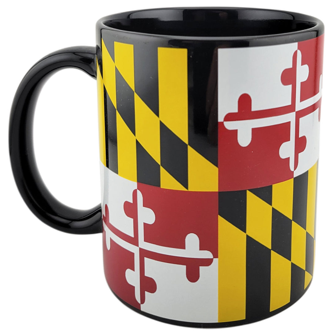 A black ceramic mug featuring the Maryland state flag design with alternating black and gold diagonal checkers and red-and-white cross quarters, shown on a plain white background.