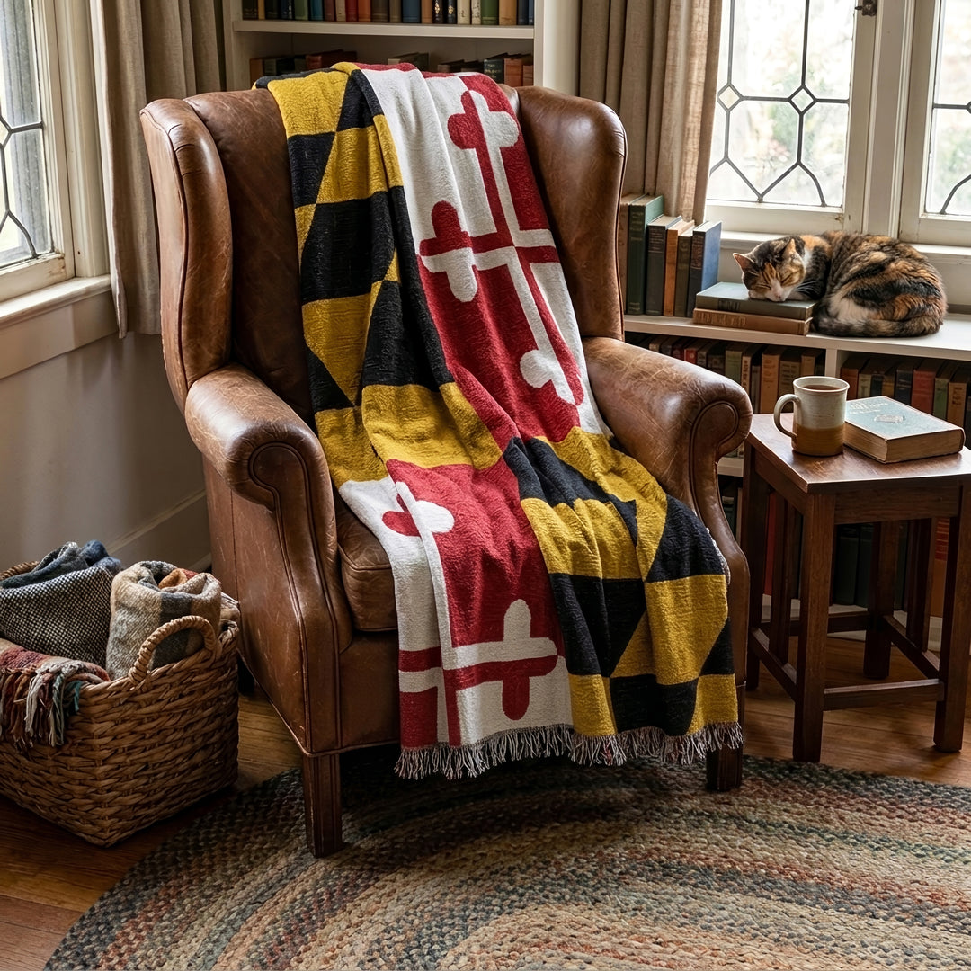 Maryland Flag Tapestry Throw Blanket across a cozy leather chair.