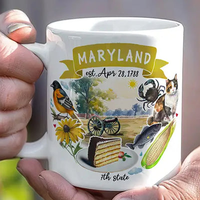 Mug with illustrations of Maryland symbols held by a hand