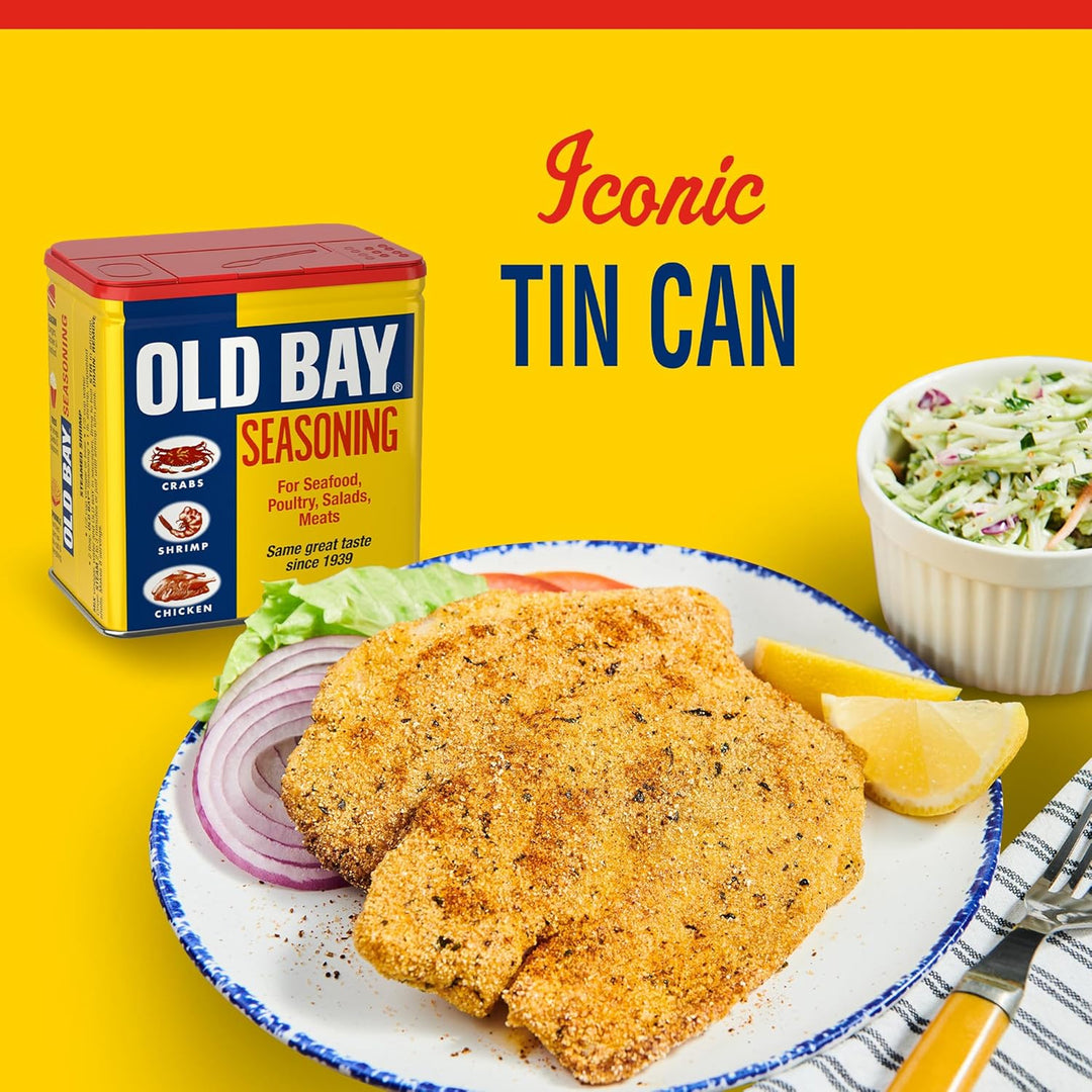 Old Bay seasoning can with fried fish and coleslaw on a yellow background