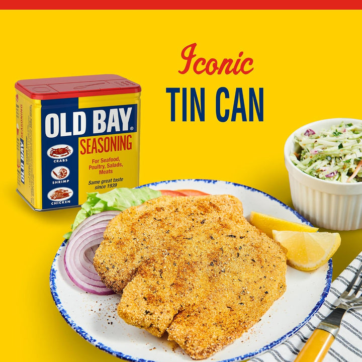 Old Bay seasoning can with fried fish and coleslaw on a yellow background