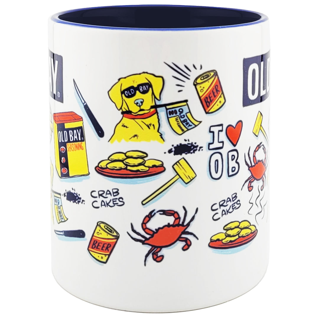 A white ceramic coffee mug with a dark navy blue interior and rim, decorated with colorful cartoon illustrations of an Old Bay dog, crab cakes, a red crab, beer cans, a crab mallet, and the text &