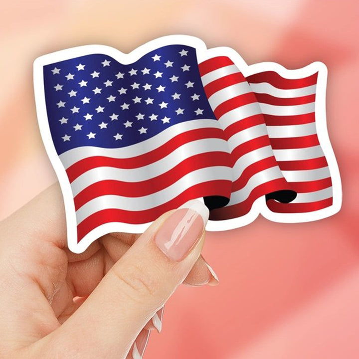 Waving American Flag Die Cut Vinyl Sticker being held by a hand.